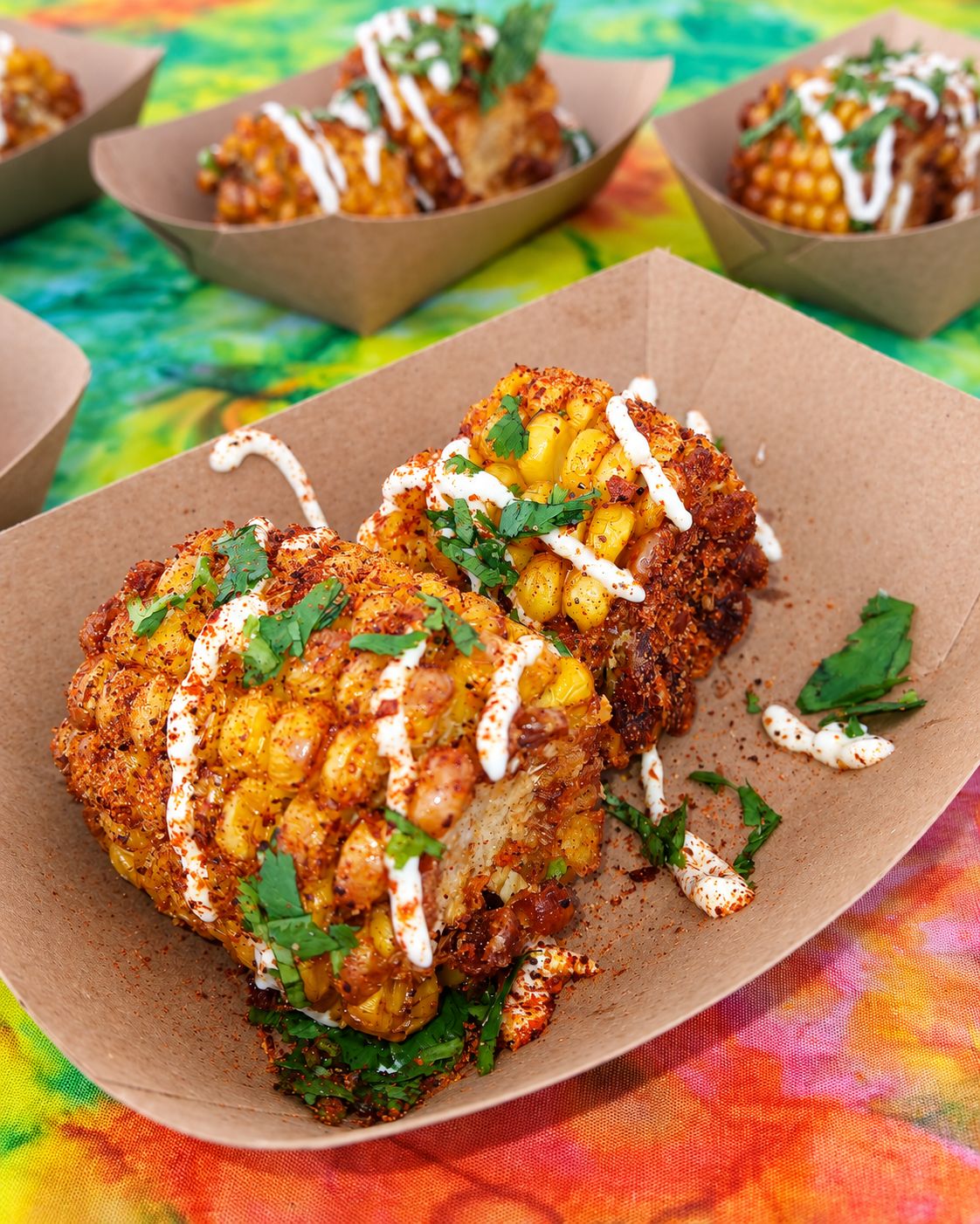 Golden corn in kraft boats, topped with sauce and fresh herbs, at Chef Marcella’s previous SOBEWFF appearance